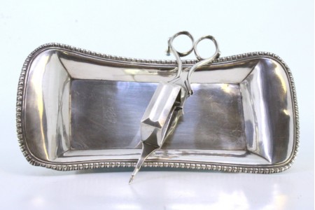 Bandeja e tesoura de morrões em prata lisa com frisos e assente em quatro pés em forma de garras.